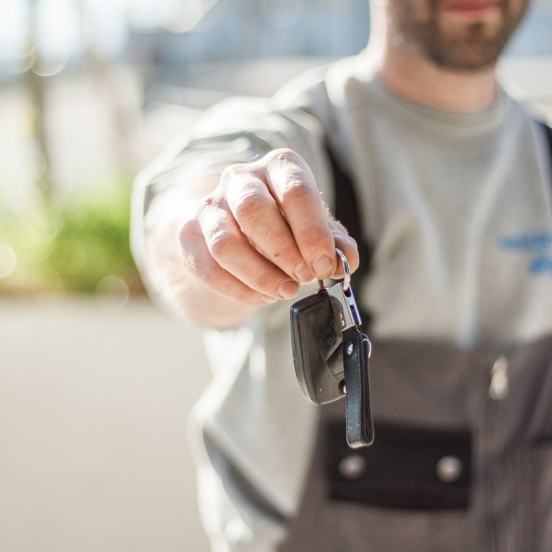 homme qui tend une clé après un nettoyage de voiture en Martinique